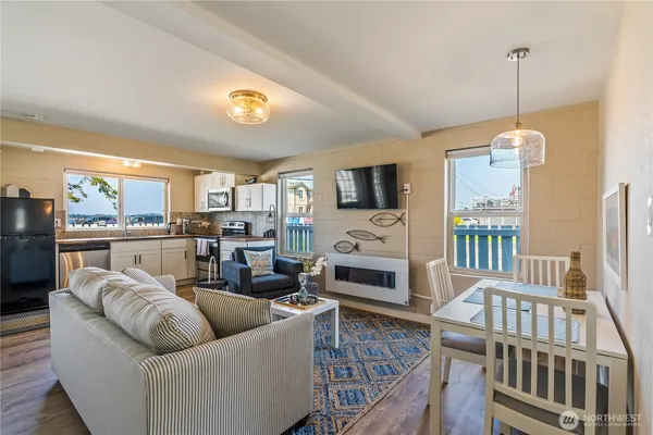 a living room with stainless steel appliances furniture and a fireplace