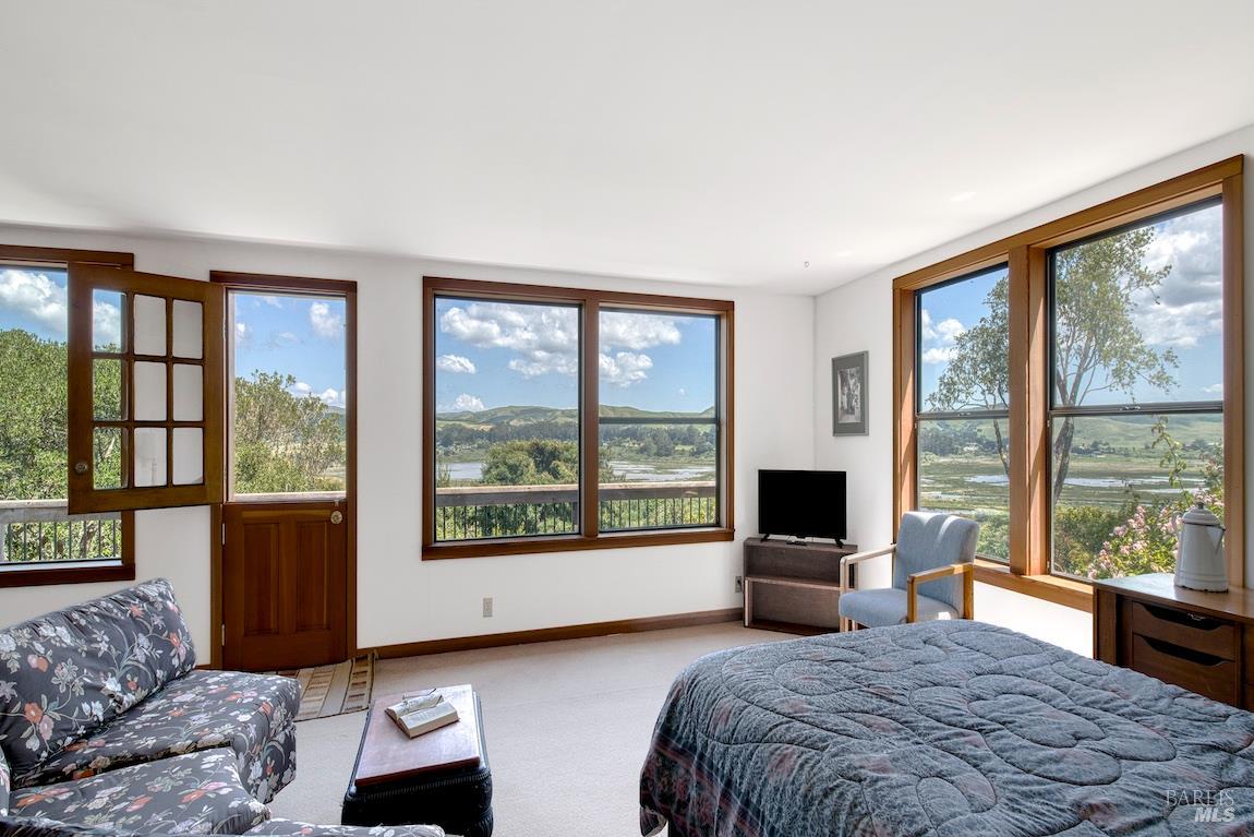 57 Laurel Street Inverness, CA 94956 - Photo 30 of 45 a bedroom with a large bed and a large window