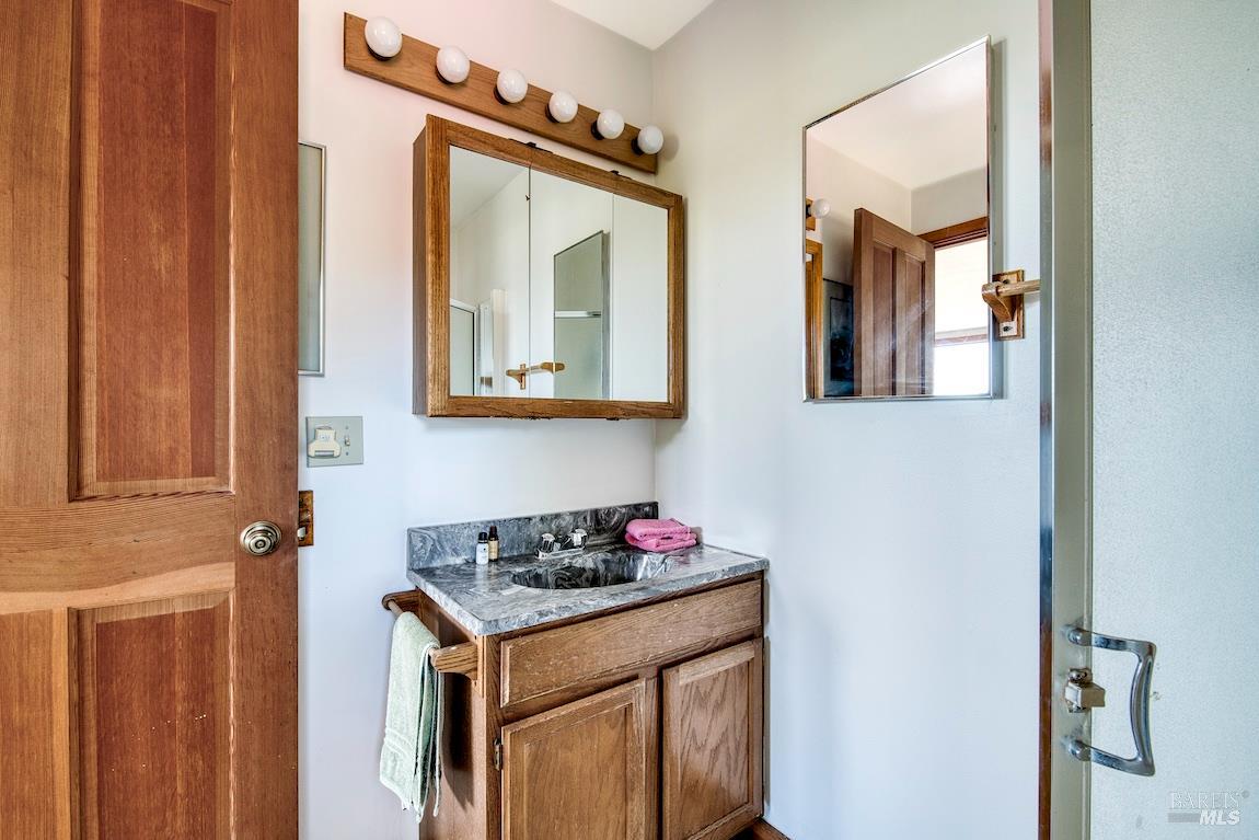57 Laurel Street Inverness, CA 94956 - Photo 36 of 45 a bathroom with a granite countertop sink and a mirror