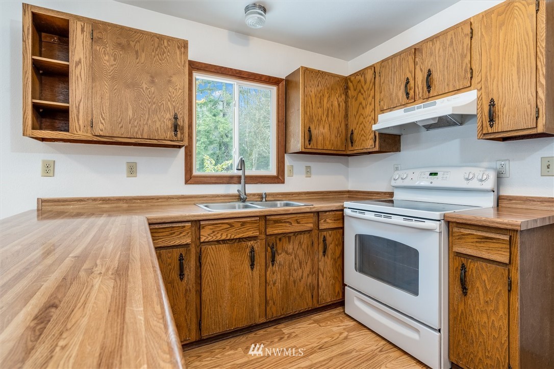131 Tingle Road Winlock, WA 98596 - Photo 10 of 31 a kitchen with stainless steel appliances granite countertop a sink a stove and a wooden cabinets