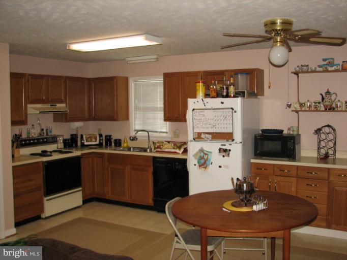 218 Long View Road Linden, VA 22642 - Photo 11 of 16 a kitchen with stainless steel appliances granite countertop a sink dishwasher stove top oven with cabinets and wooden floor