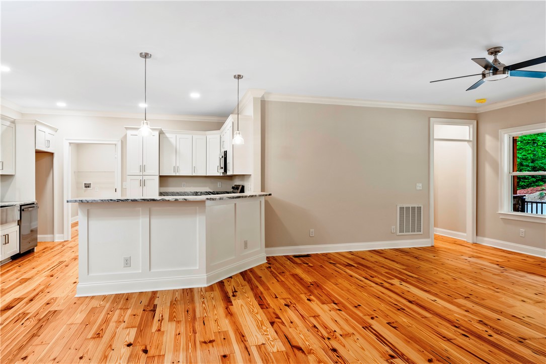110 Gabriel Way Pickens, SC 29671 - Photo 3 of 48 Hearty wood floors extend through the combined kitchen and living areas, offering a fluid, warm ambiance.