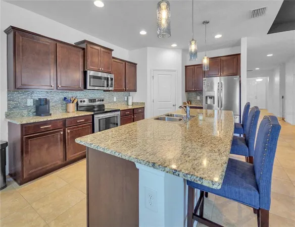 a kitchen with stainless steel appliances granite countertop wooden cabinets a stove top oven a sink and dishwasher