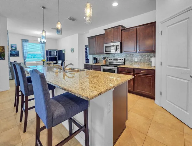 a large kitchen with kitchen island a dining table and chairs
