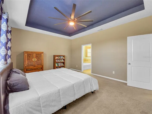 a bedroom with a large bed and a chandelier