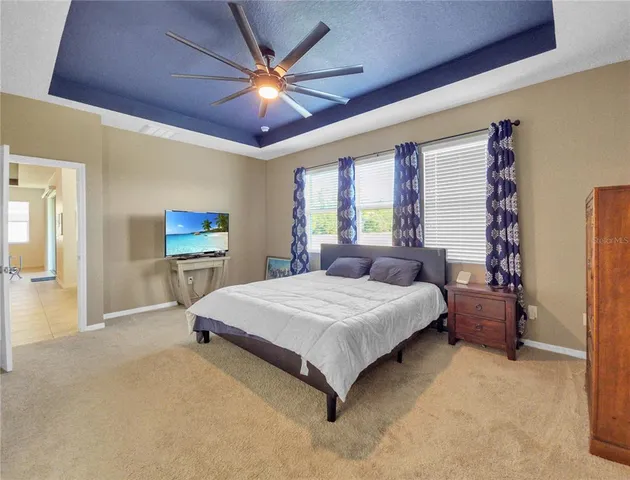 a spacious bedroom with a bed and a chandelier