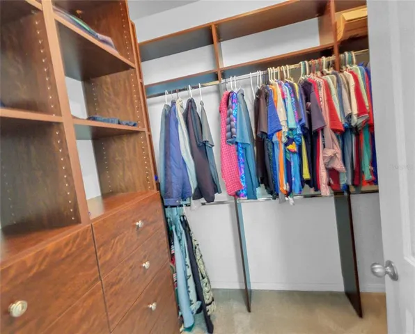 a view of walk in closet with clothes
