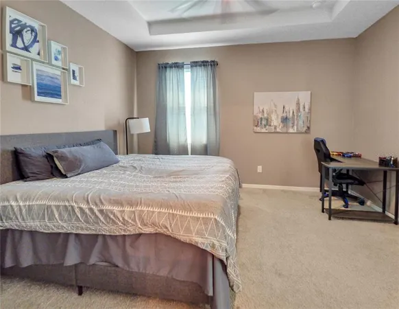 a bedroom with a bed a chair and painting on the wall