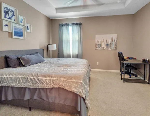 a bedroom with a bed a chair and painting on the wall