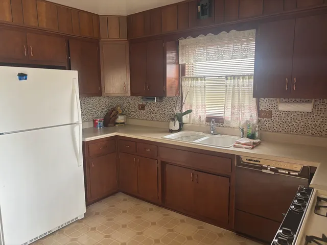 a kitchen with a sink a refrigerator and window