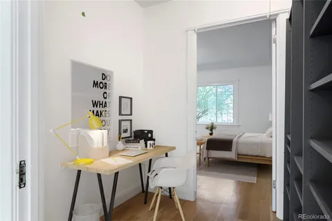 a view of a workspace with furniture and a window