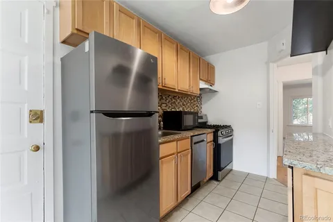 a kitchen with stainless steel appliances granite countertop a refrigerator and a stove