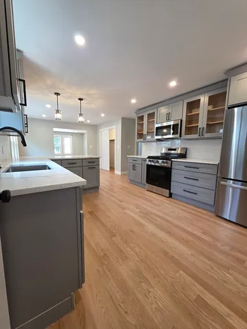 a kitchen with stainless steel appliances granite countertop a refrigerator a stove and a sink