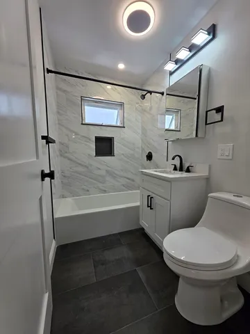 a bathroom with a toilet sink and mirror