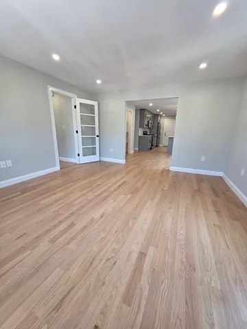a view of empty room with wooden floor and stove