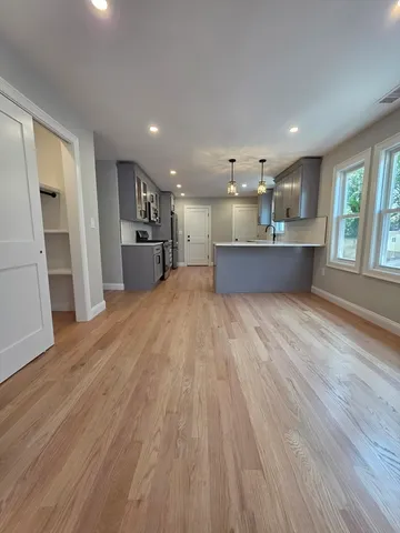 a large space with kitchen island wooden floors and stainless steel appliances