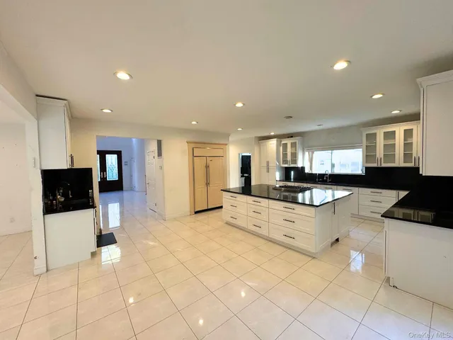 a large white kitchen with a refrigerator and a counter top space