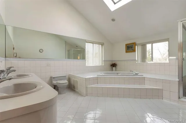 a spacious bathroom with a bathtub sink and mirror