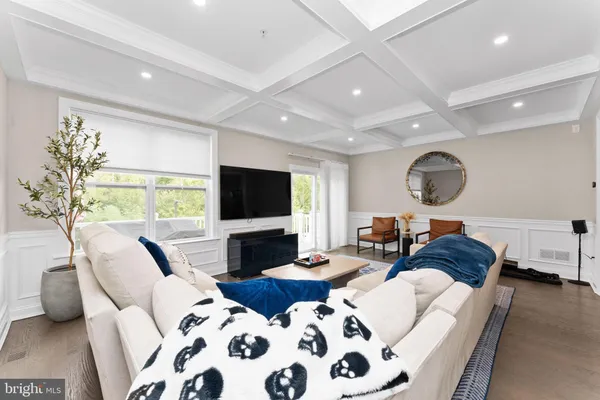 a living room with furniture a flat screen tv and a large window