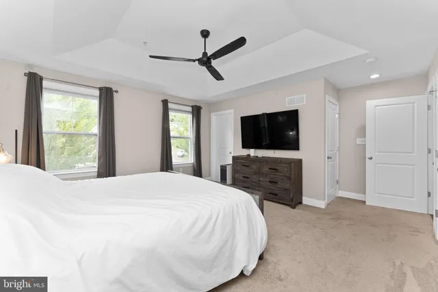 a spacious bedroom with a bed and a flat screen tv
