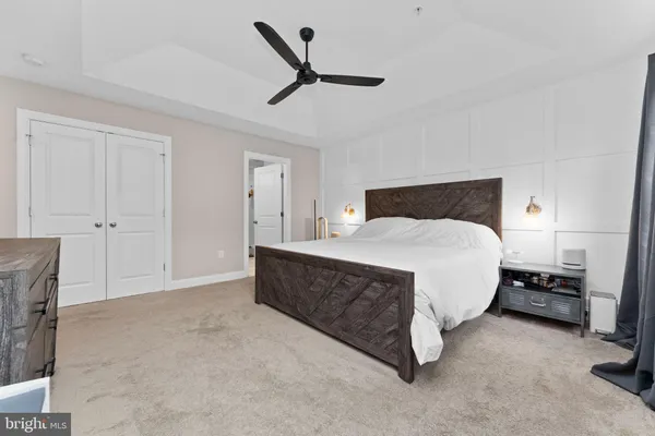 a spacious bedroom with a bed and a ceiling fan