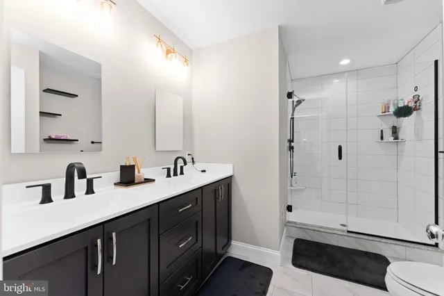 a bathroom with a double vanity sink toilet and shower