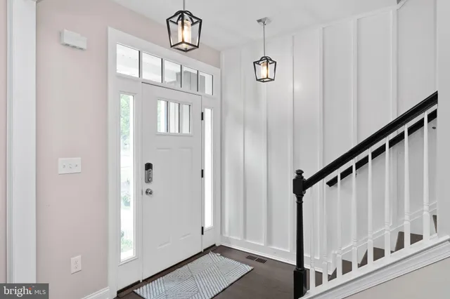 a view of staircase with lots of frames on wall and a large window