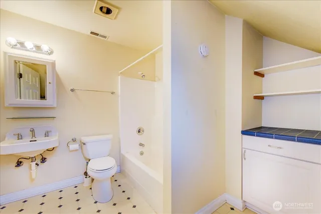 a bathroom with a toilet a sink and a shower