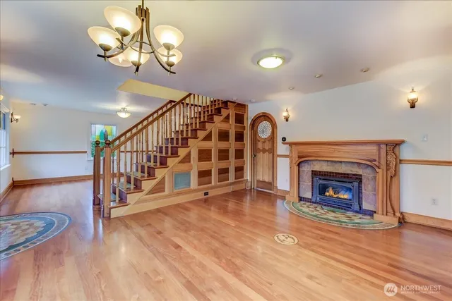 a view of an empty room with wooden floor and a fireplace