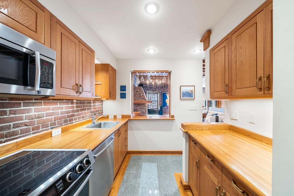 436 Lewis Wharf, Unit 436 Boston, MA 02110 - Photo 11 of 40 a kitchen with stainless steel appliances a sink stove top oven and cabinets