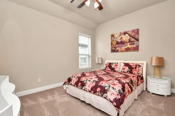 a bedroom with a bed and a painting on the wall