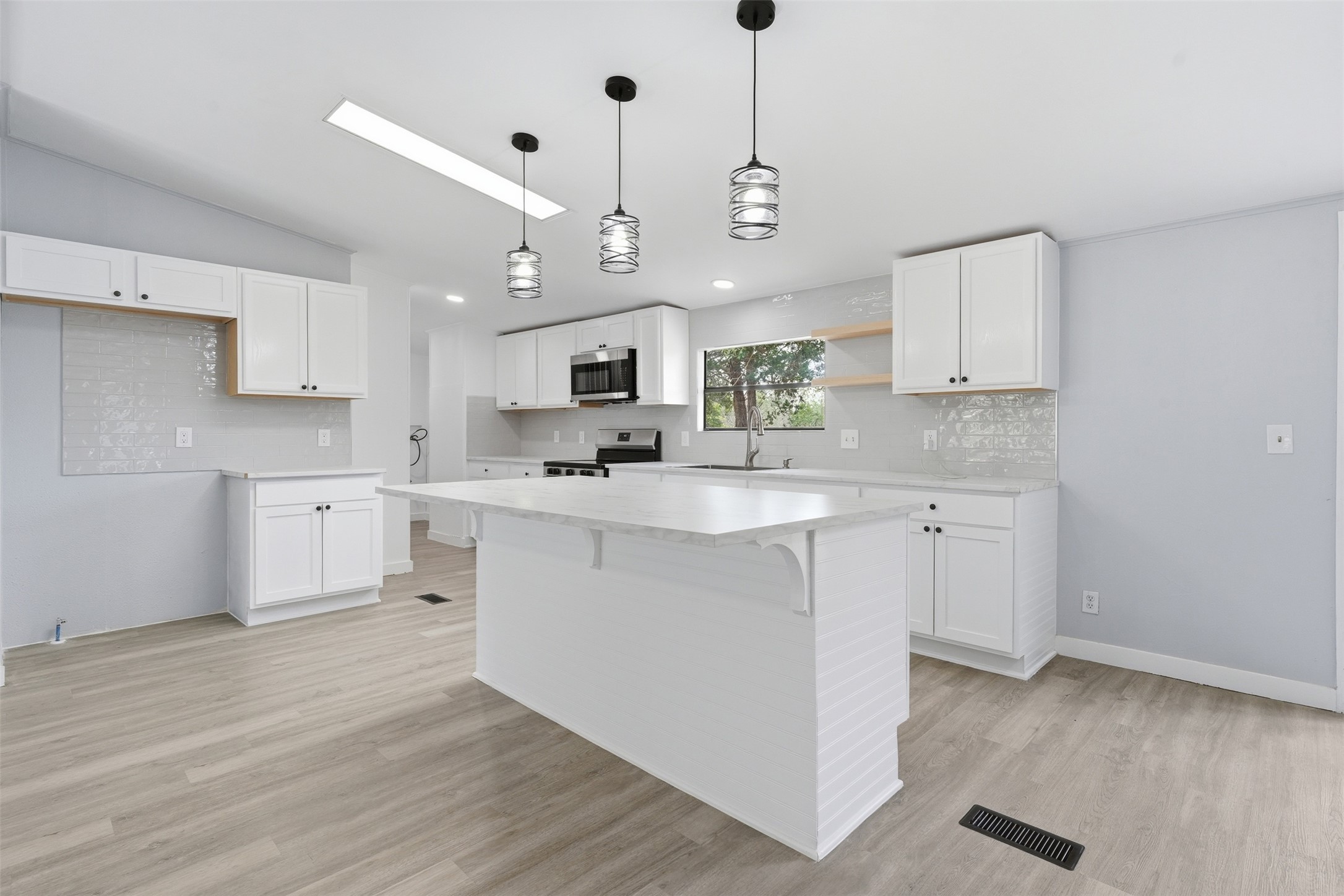 154 Antioch Road Smithville, TX 78957 - Photo 6 of 32 A pristine kitchen features ample white cabinetry, a functional island, and contemporary overhead lighting.