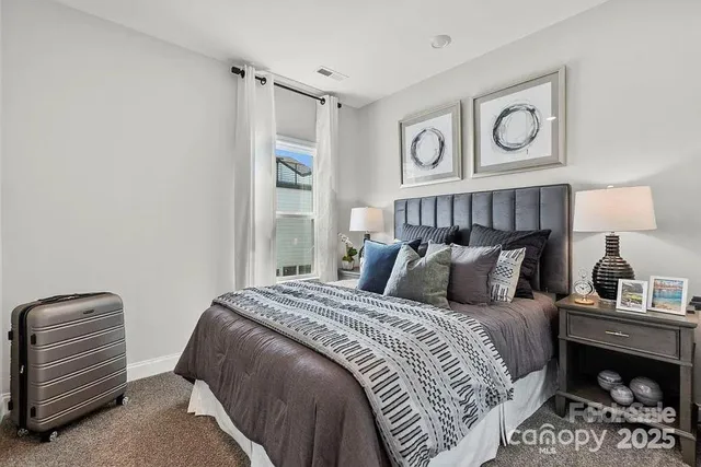 a bedroom with a bed and a lamp on the dresser