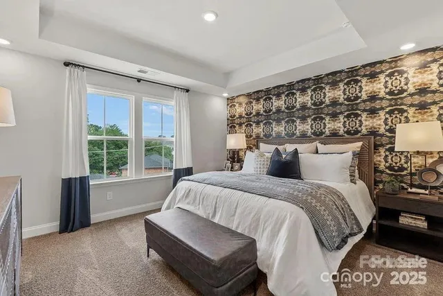 a bedroom with a bed a mirror on dresser and a dresser