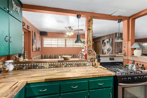 a view of a kitchen with kitchen island granite countertop a sink and a stove