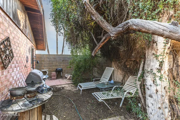 a view of backyard with outdoor seating and barbeque oven