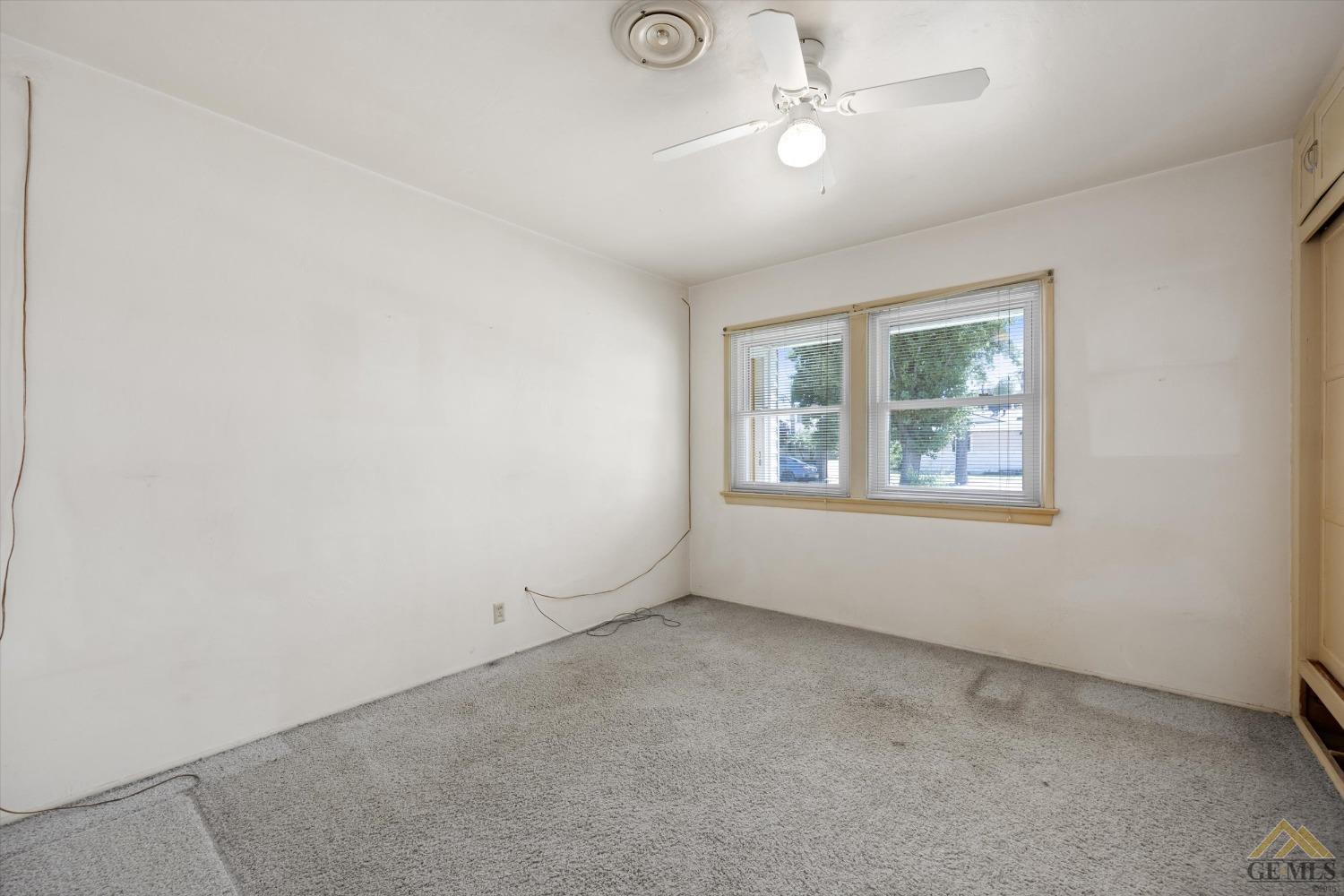 Undisclosed Address Wasco, CA 93280 - Photo 13 of 21 an empty room with windows and fan
