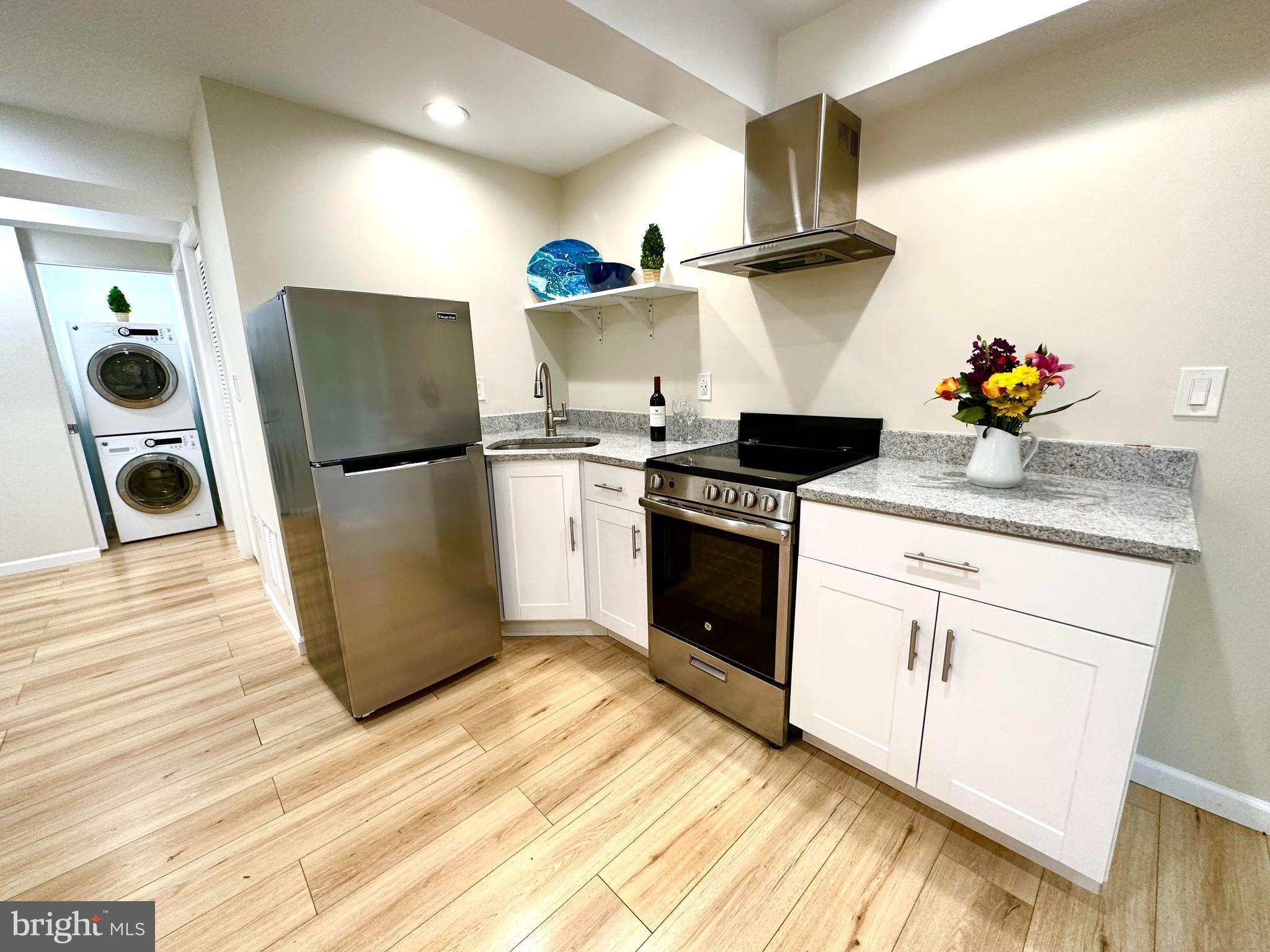 8301 Windfall Road Springfield, VA 22153 - Photo 6 of 22 a kitchen with stainless steel appliances granite countertop a refrigerator a stove and a granite countertops with wooden floor