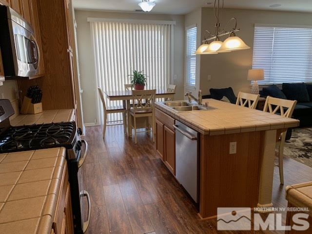 2581 Spring Flower Drive Reno, NV 89521 - Photo 4 of 14 a kitchen with a stove a sink a dining table and chairs