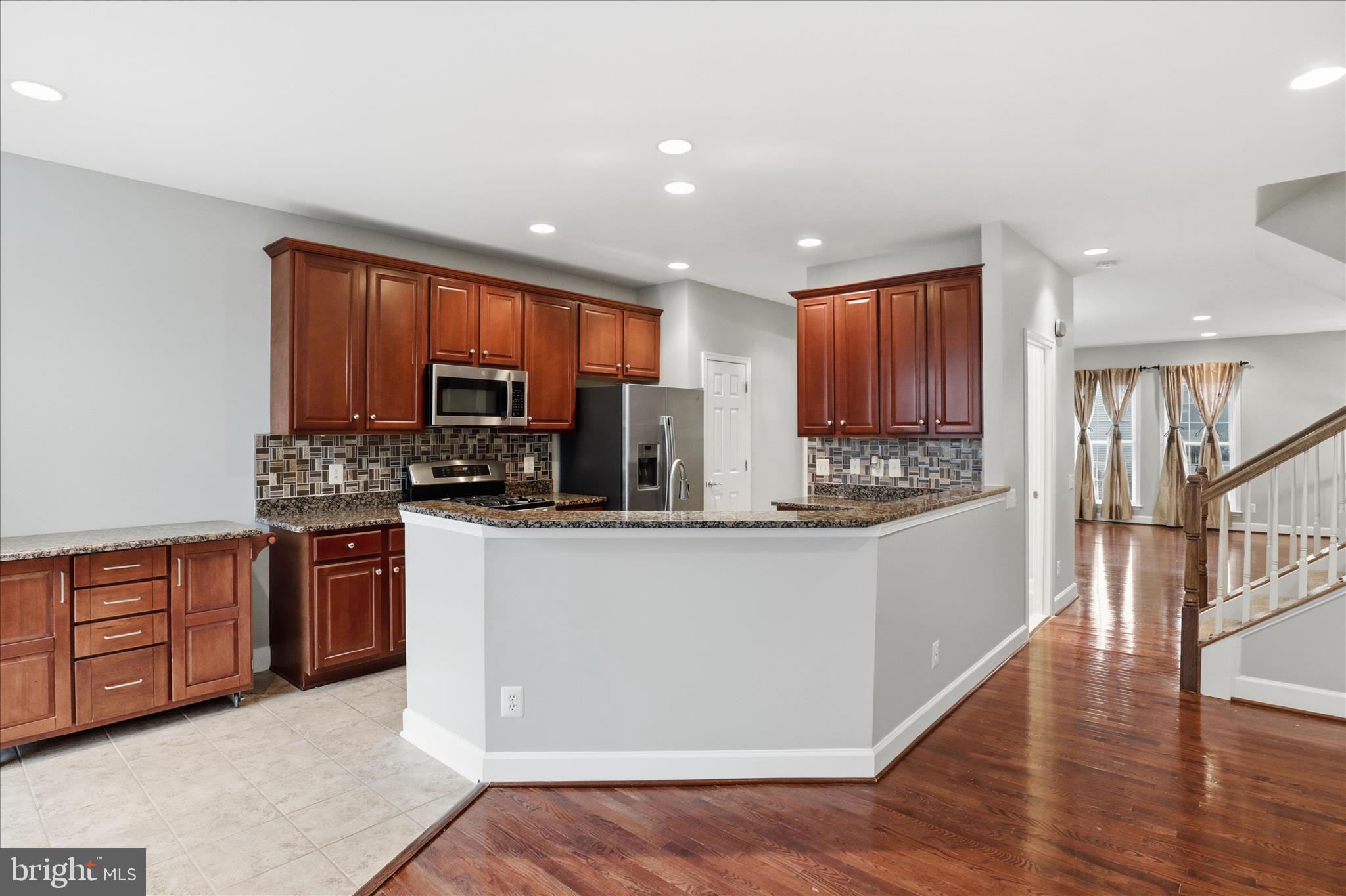 42906 Bittner Square Ashburn, VA 20148 - Photo 8 of 31 a kitchen with stainless steel appliances granite countertop wooden cabinets a stove a sink and a refrigerator