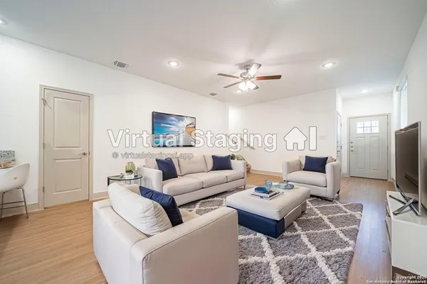a living room with furniture a wooden floor and a flat screen tv