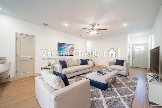 a living room with furniture a wooden floor and a flat screen tv