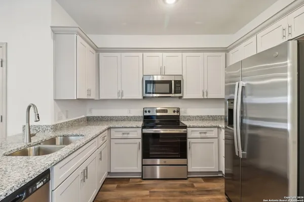 a kitchen with stainless steel appliances granite countertop a refrigerator sink and stove