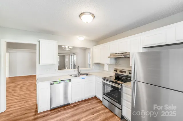 a kitchen with a refrigerator and a stove top oven