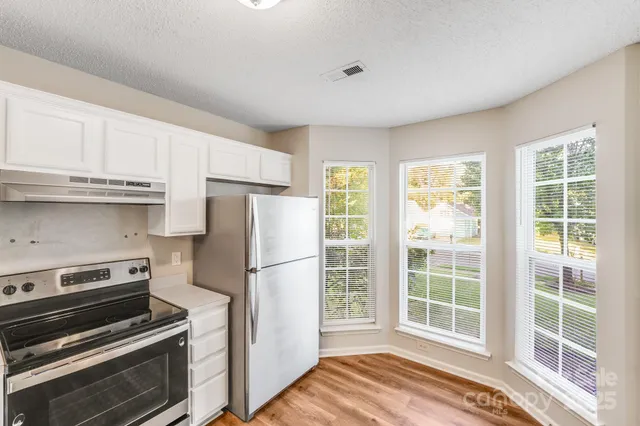 a kitchen with stainless steel appliances a stove a refrigerator and a window