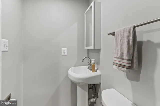 a bathroom with a sink a toilet and a mirror