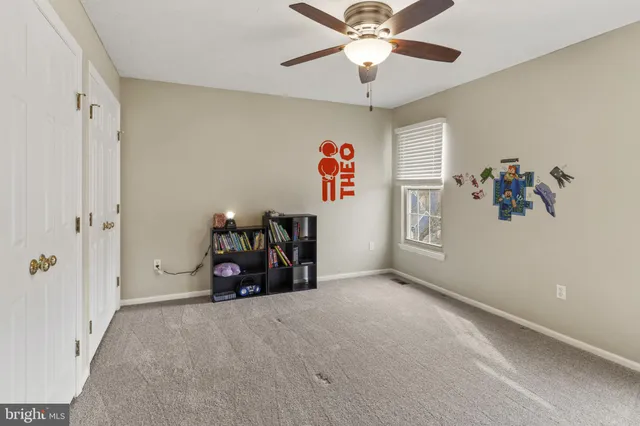 wooden floor with ceiling fan and window
