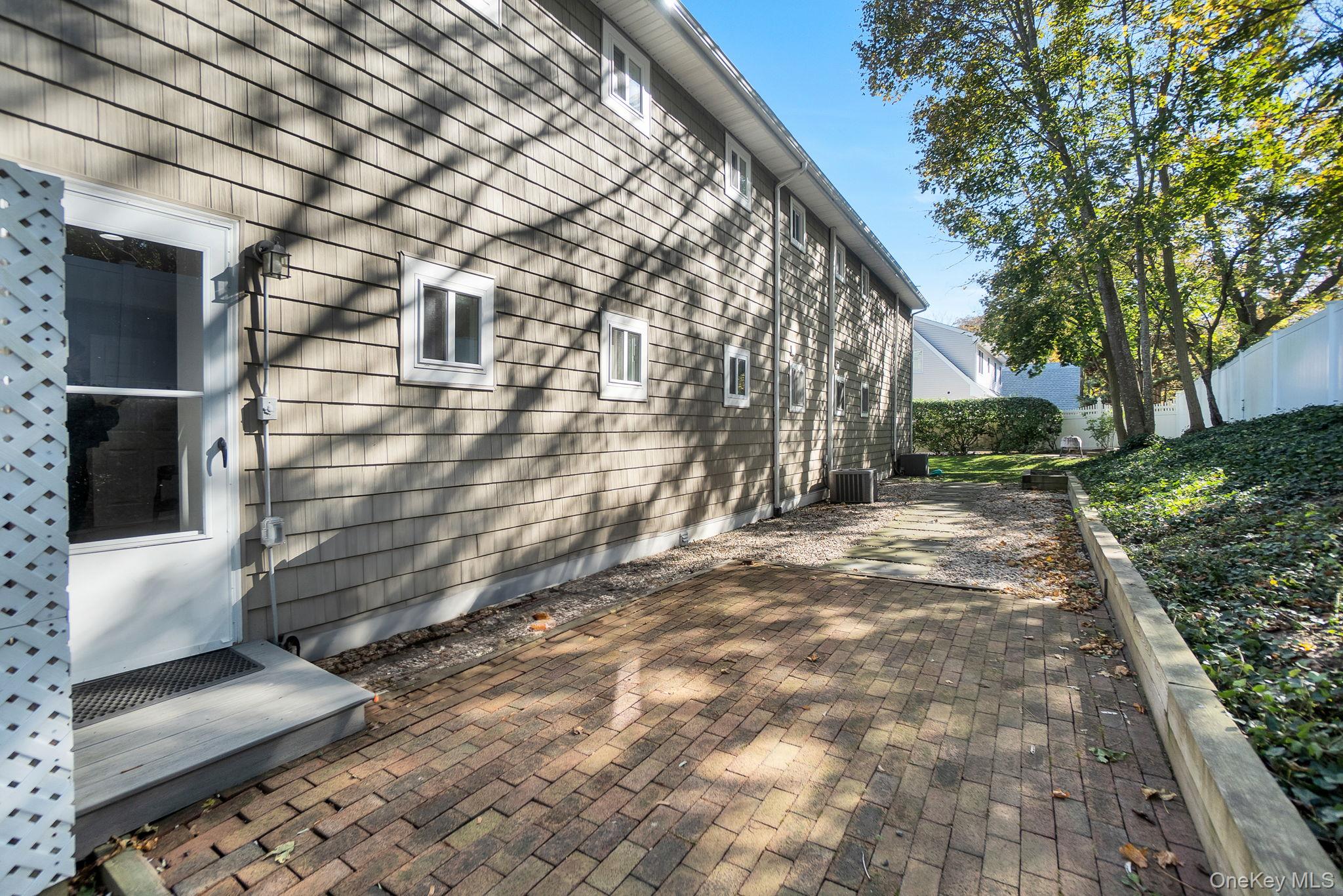62 Canoe Place Road, Unit 513/5 Hampton Bays, NY 11946 - Photo 11 of 15 View of side of home featuring a patio area
