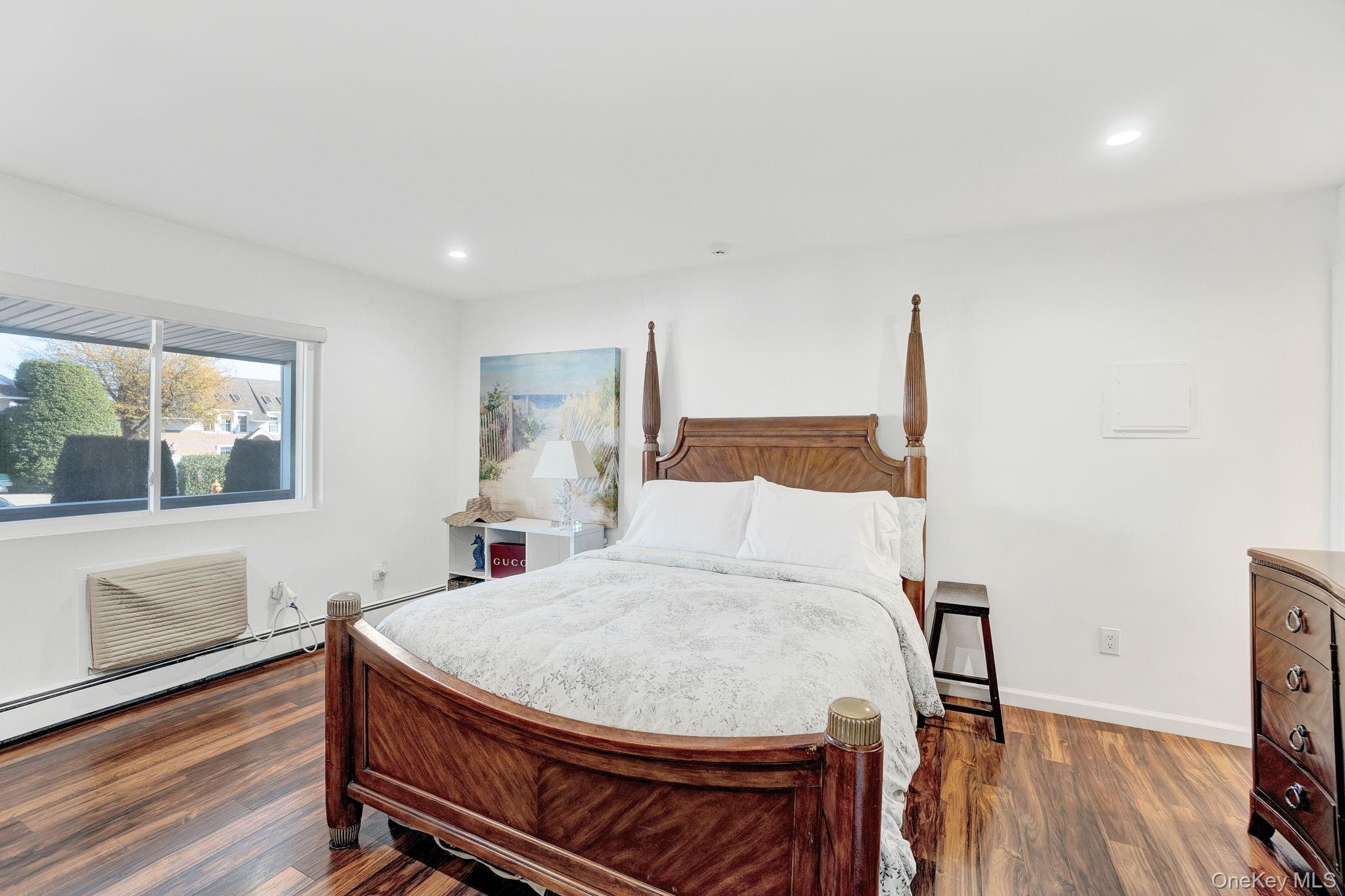 62 Canoe Place Road, Unit 513/5 Hampton Bays, NY 11946 - Photo 7 of 15 Bedroom with dark wood finished floors, recessed lighting, and a wall mounted AC