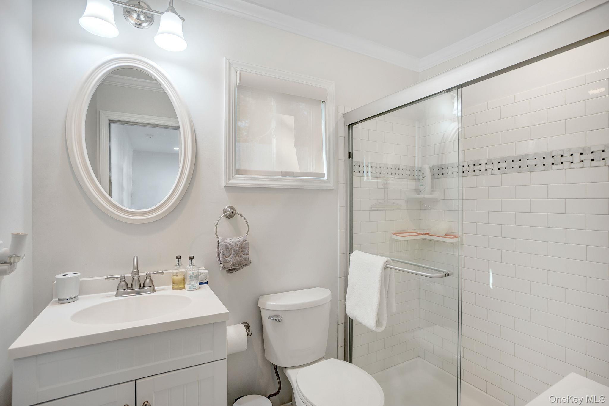 62 Canoe Place Road, Unit 513/5 Hampton Bays, NY 11946 - Photo 8 of 15 Full bath featuring vanity, ornamental molding, and a stall shower